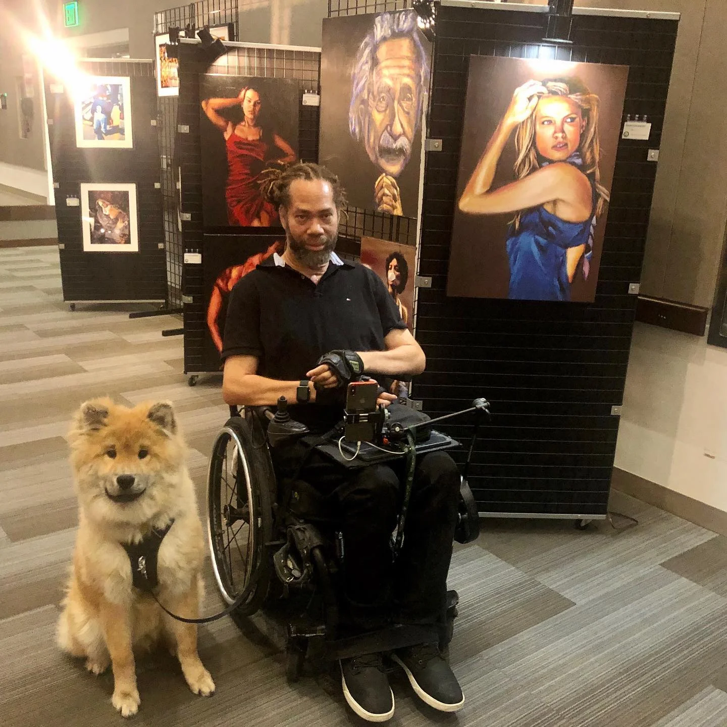 um homem em uma cadeira de rodas com um cachorro à sua frente