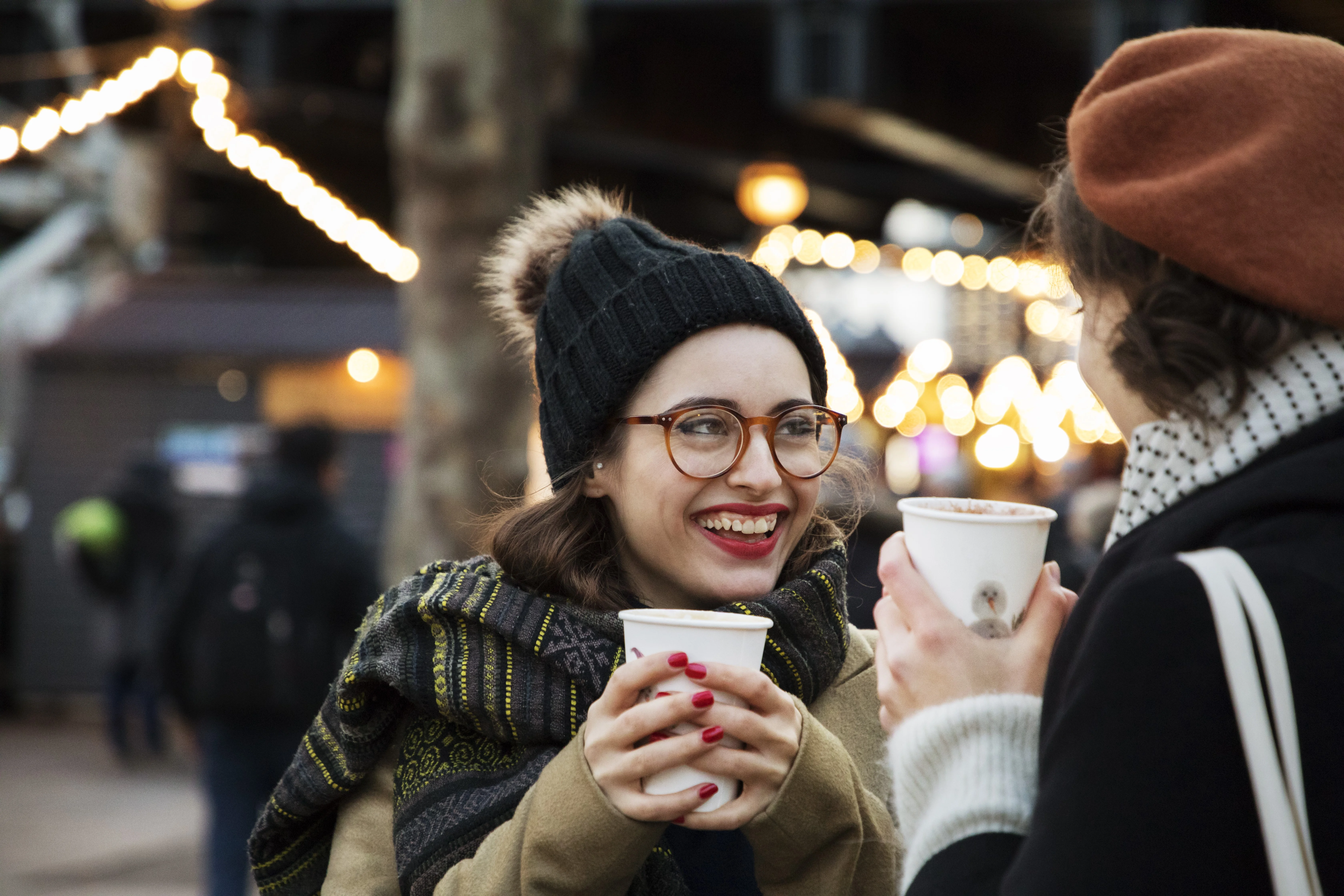 una persona che tiene in mano una tazza e un telefono cellulare