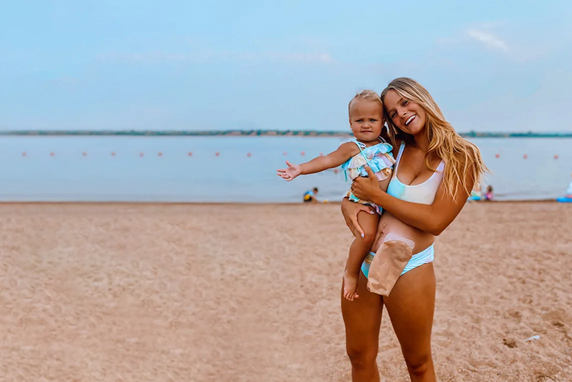 una donna che tiene una ragazza su una spiaggia