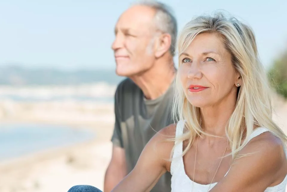 um homem e uma mulher em pé em uma praia