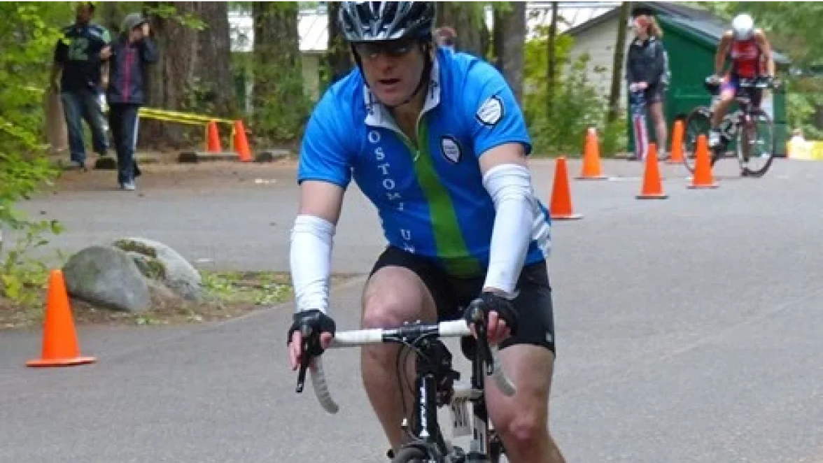 En man med stomi som njuter av sin cykeltur under sitt triathlon.